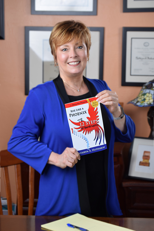Photo of attorney Kathryn Hathaway holding her book Rise Like a Phoenix: The 12 Steps of Bankruptcy